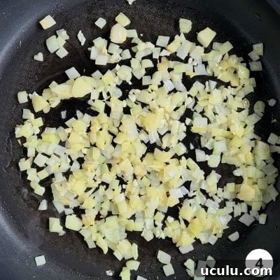 Finely diced ontions and minced garlic sauteing on a nonstick pan