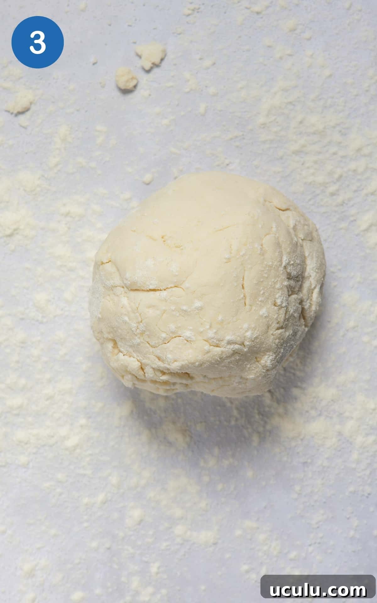 dough for naan rolled into ball on a floured work surface.