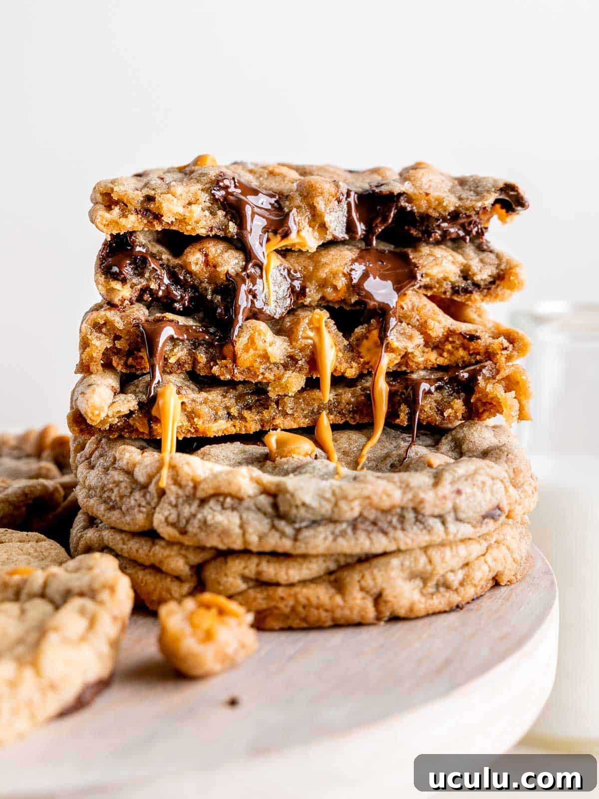 A stack of cookies with melty chocolate and butterscotch dripping down the middles.