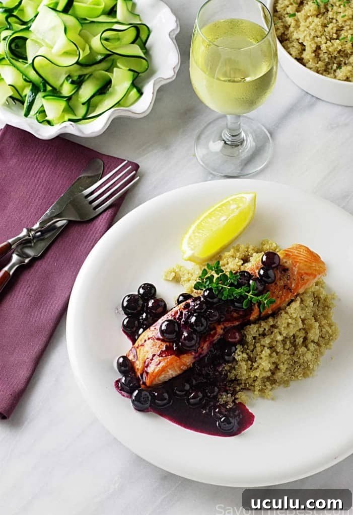 A serving plate with salmon, blueberry sauce, and quinoa. 