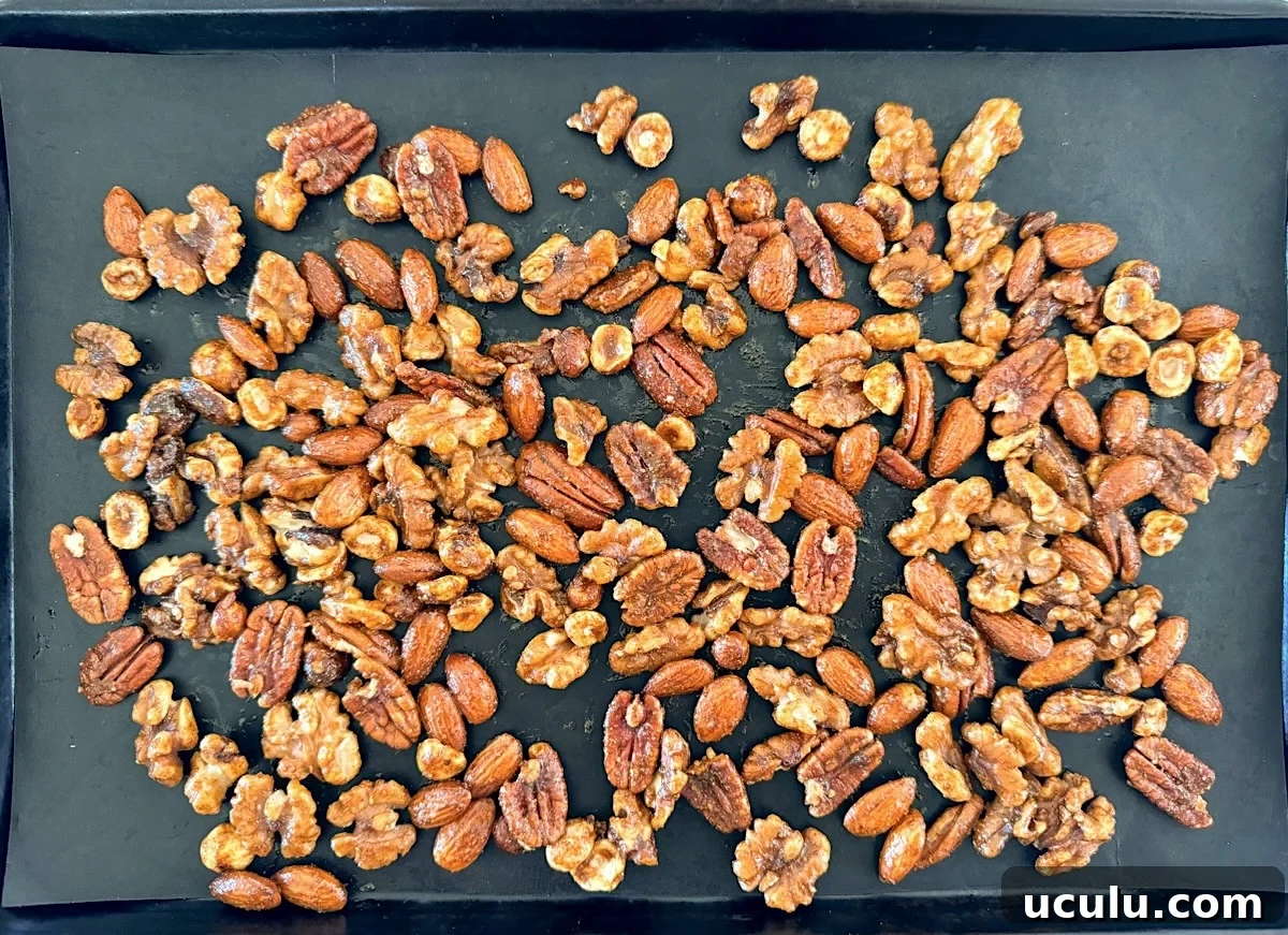 coated nuts spread on lined baking sheet