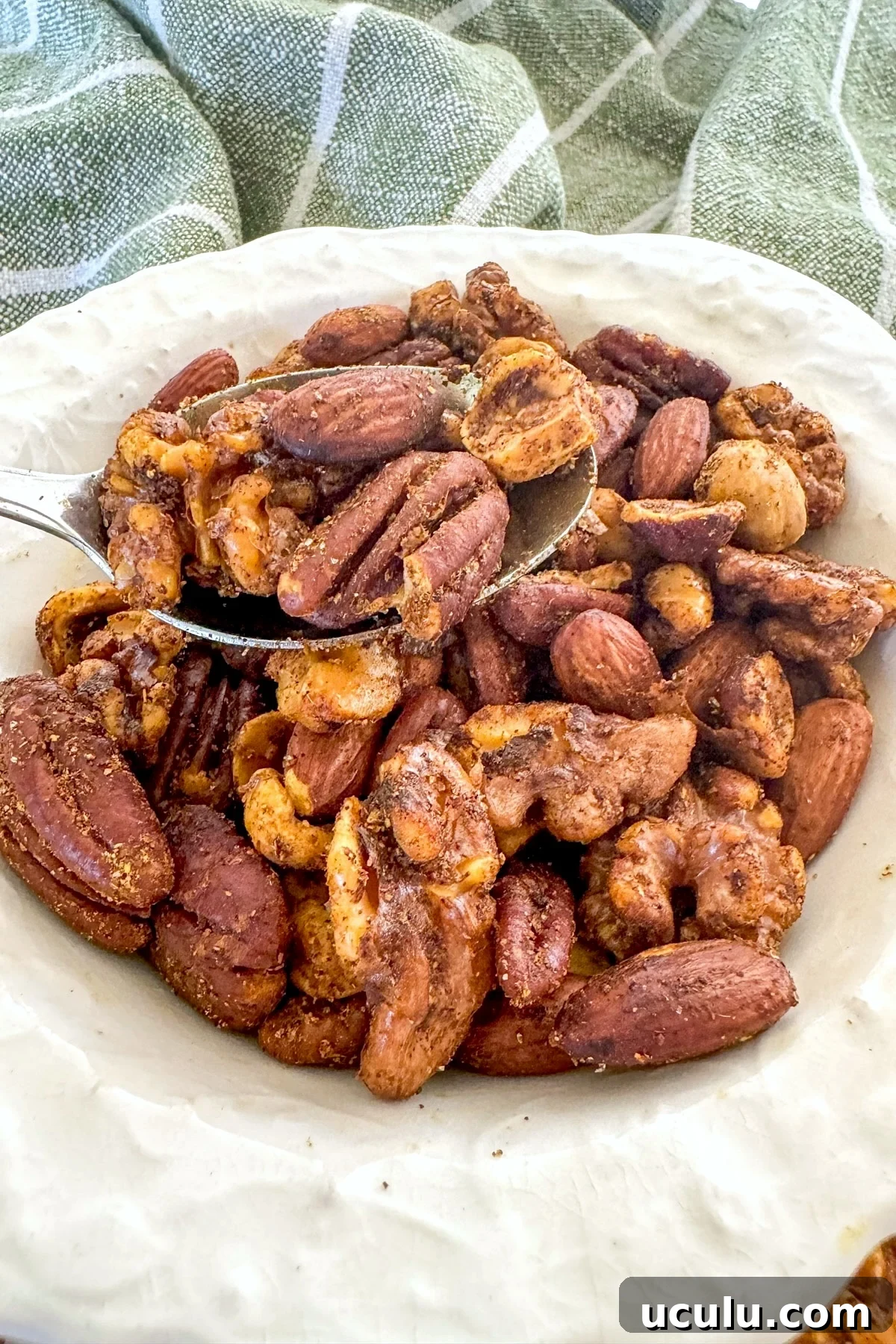 scooping nuts from a white bowl