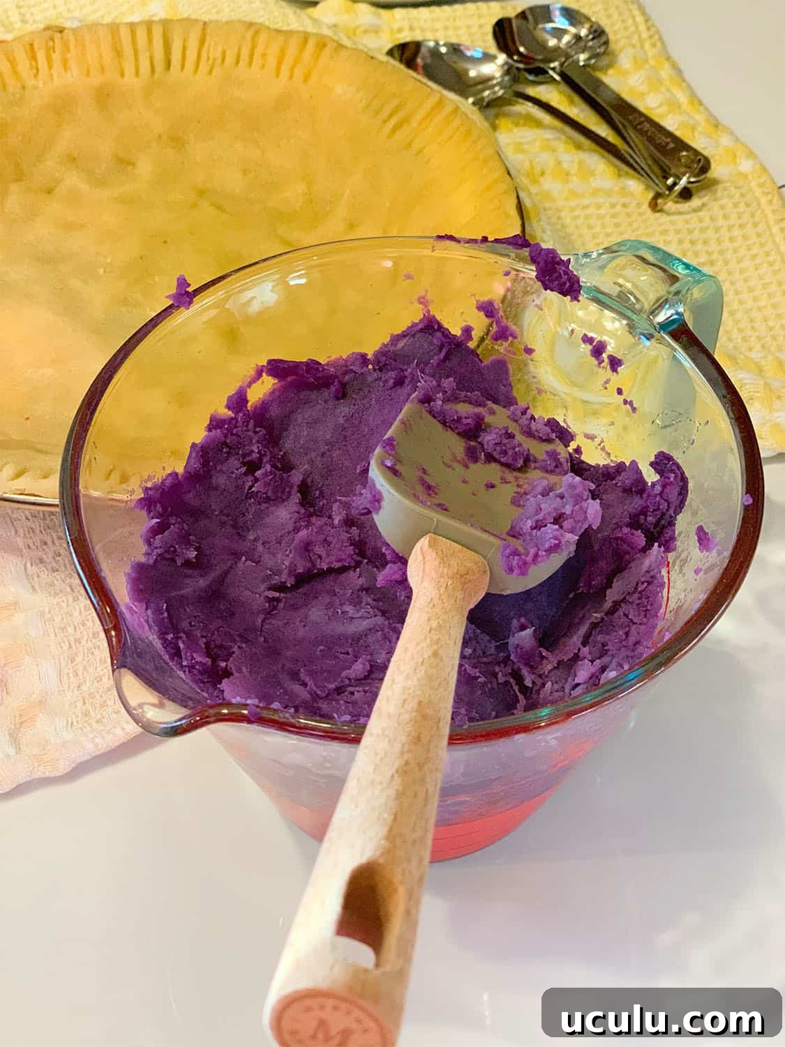 Mashed purple sweet potatoes in mixing bowl with pie crust—prep step for Black folks’ purple sweet potato pie with evaporated milk by The Soul Food Pot®