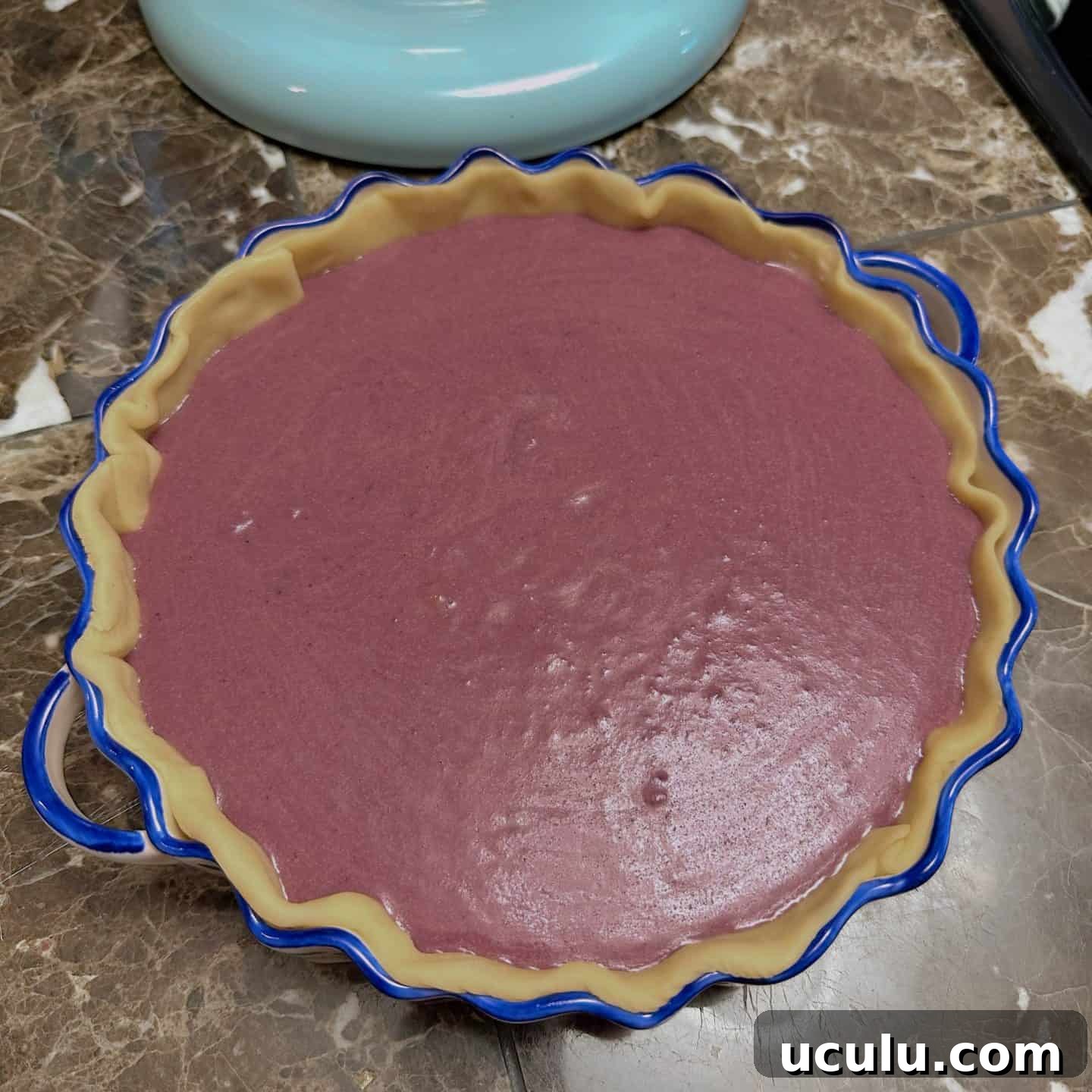 Unbaked purple sweet potato pie filling poured into crust—before baking step in Black folks’ soul food pie recipe by The Soul Food Pot®