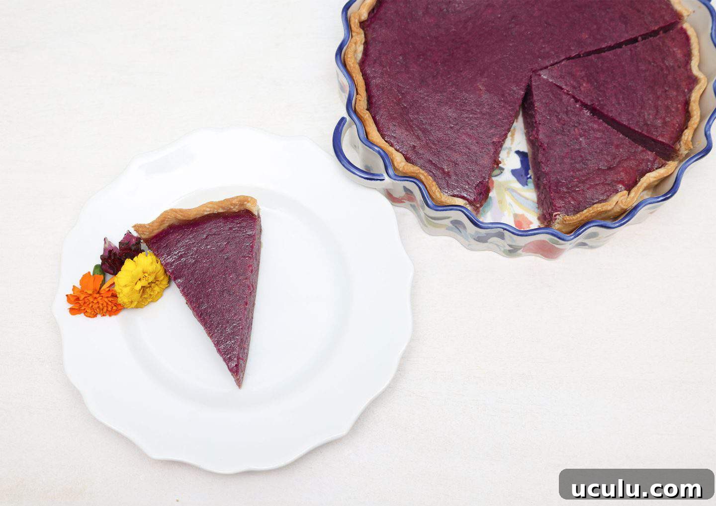 Slice of Black folks’ purple sweet potato pie served on plate with full pie in background—rich, creamy, and baked to perfection by The Soul Food Pot®