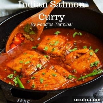 Indian Salmon curry in an iron wok with a wooden spatula