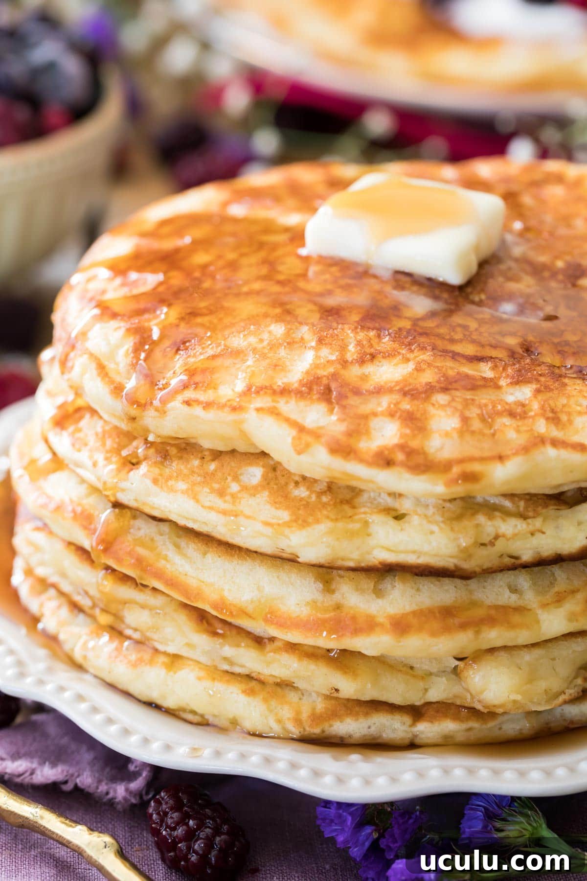buttermilk pancakes on white plate with butter