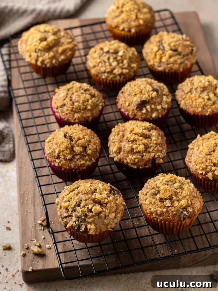 large wooden cutting board, banana muffins on a cooling rack