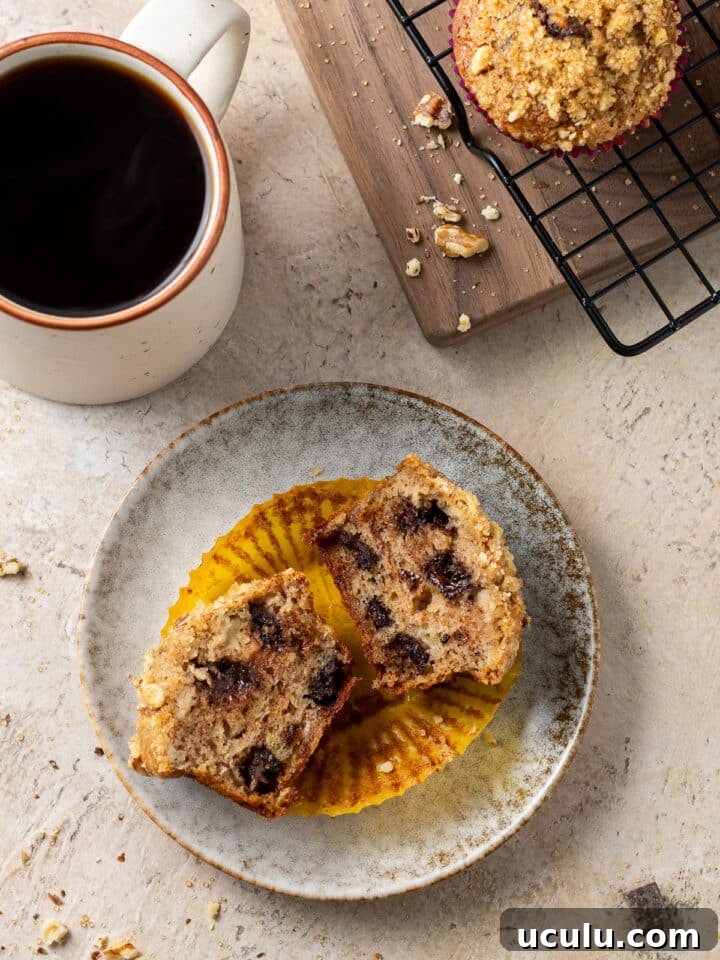 chocolate chunk banana muffin sliced in half on a plate