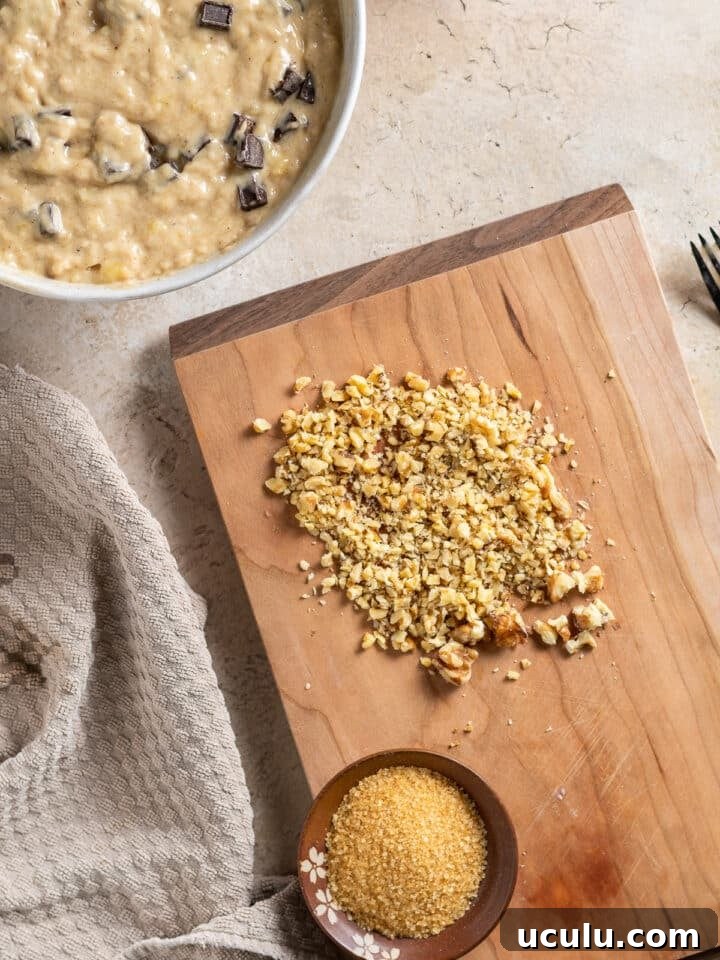 wood cutting board with chopped walnuts and a small bowl of turbinado sugar