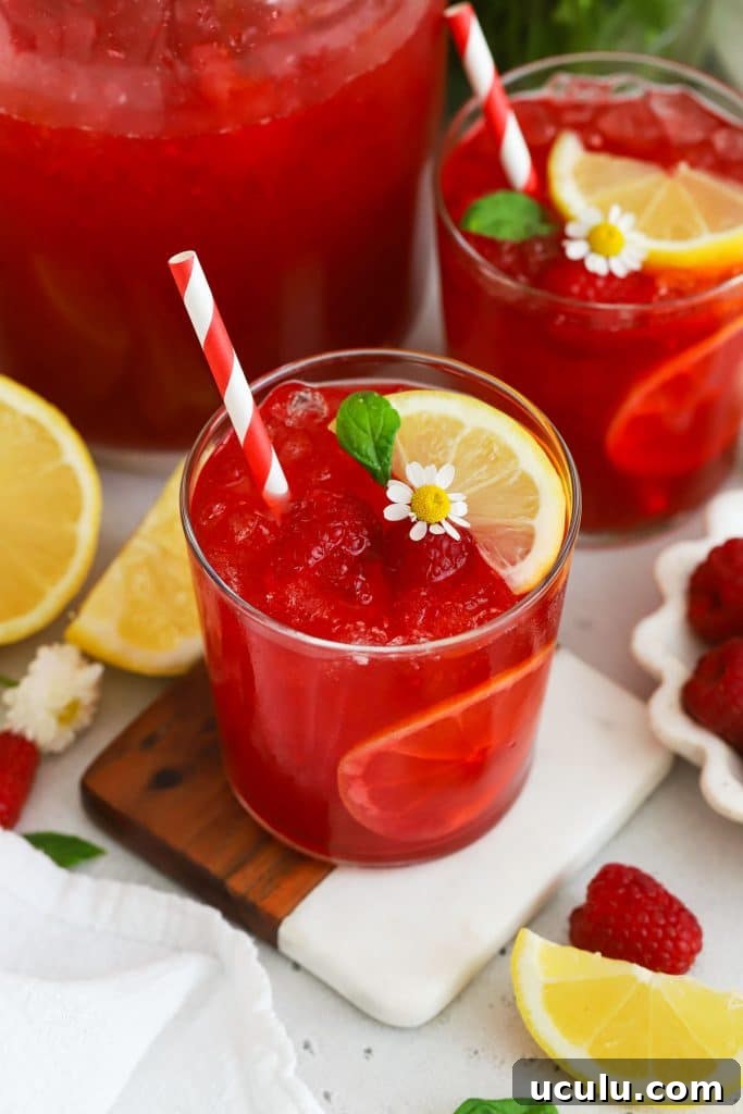 glasses of fresh raspberry lemonade garnished with mint and lemon slices