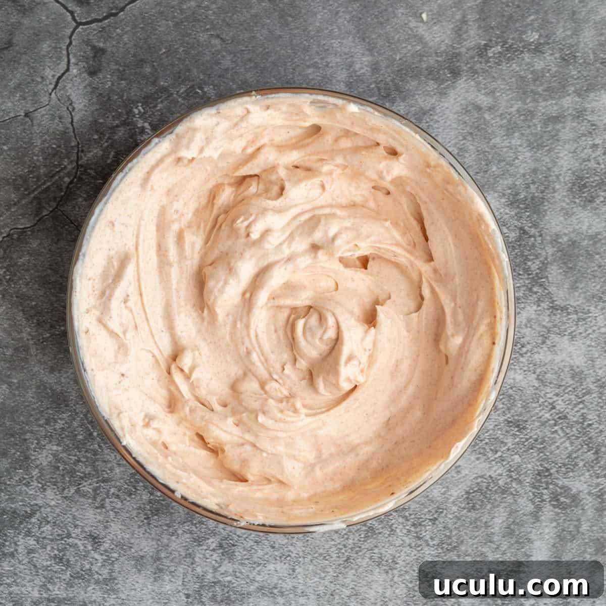 Pinkish creamy white sauce in a glass bowl.