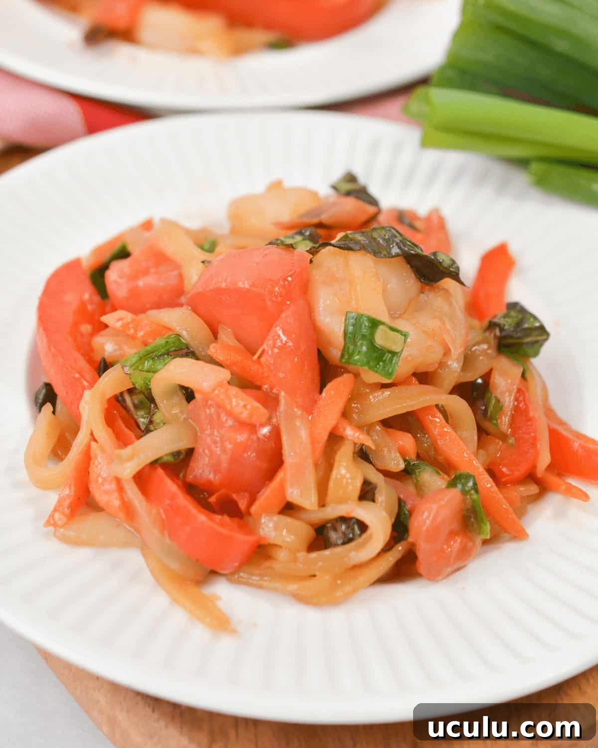 Shrimp drunken noodles on white plate.