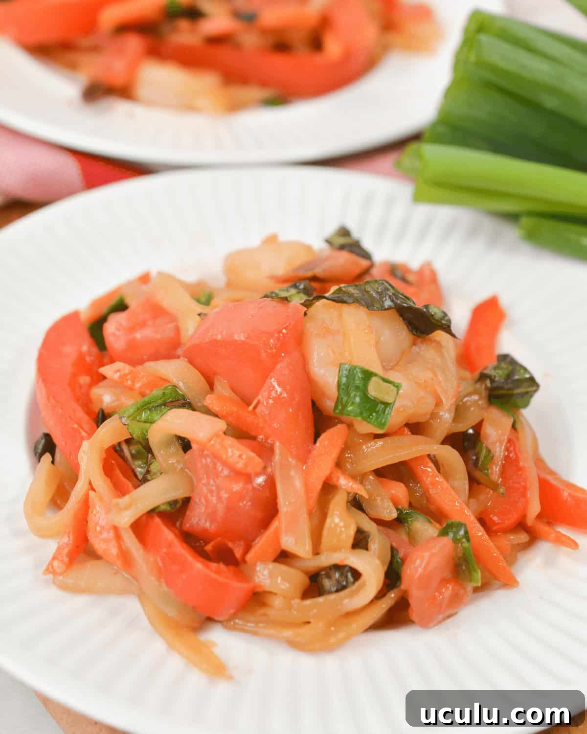 Shrimp drunken noodles on a white plate.