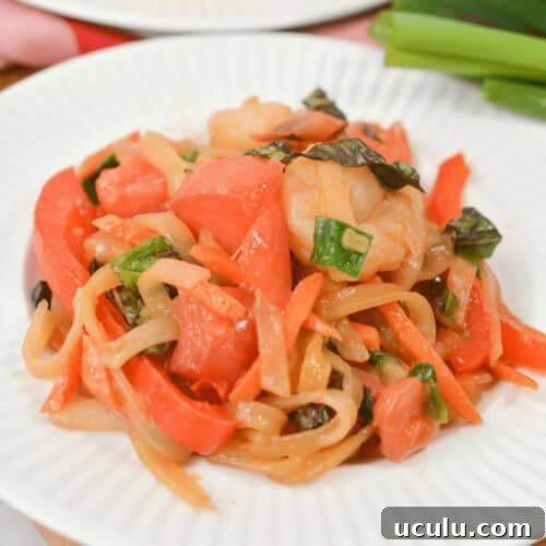 Shrimp drunken noodles on white plate.