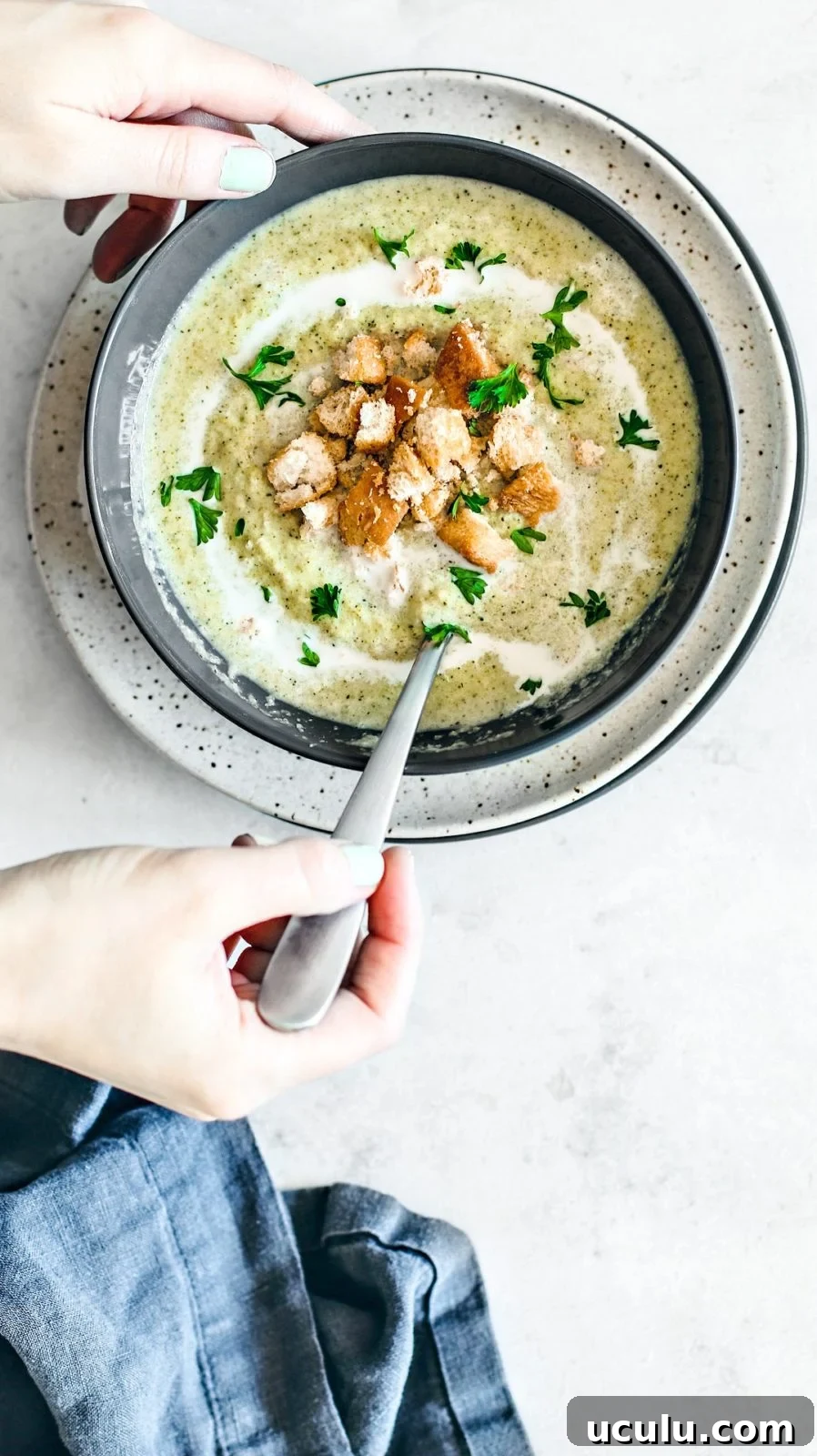 Spooning into cream of broccoli soup.