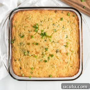 A Jiffy corn casserole baked in a dish and sprinkled with green onions.