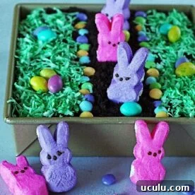 An Easter dirt cake for kids with coconut grass, m and ms, and peeps.
