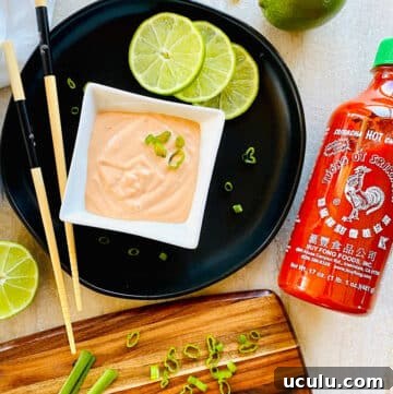 sriracha aioli recipe in a dish next to a bottle of Huy Fong Sriracha Hot Chile Sauce.