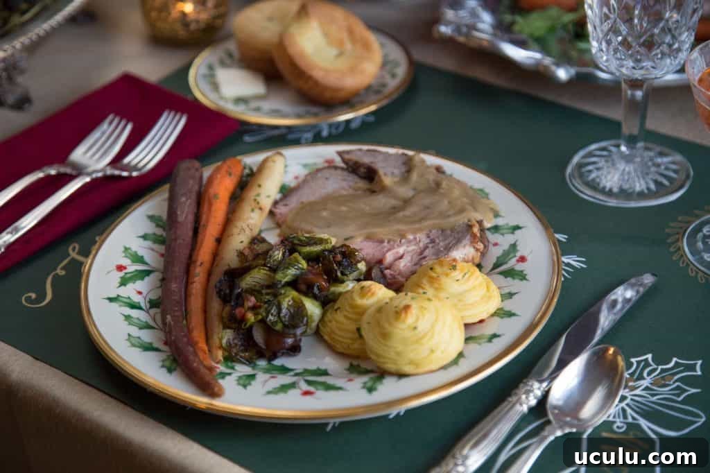 duchess potatoes, prime rib, and roasted carrots on a green and white china plate.