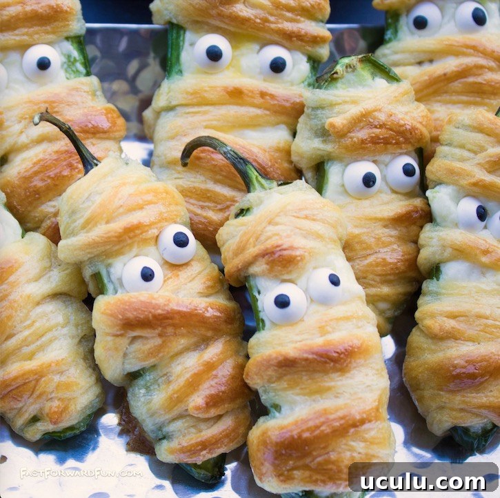 The best Halloween food idea for parties! These jalapeno mummies are a delicious appetizer for adults made with peppers, cream cheese and Pillsbury crescent dough. 