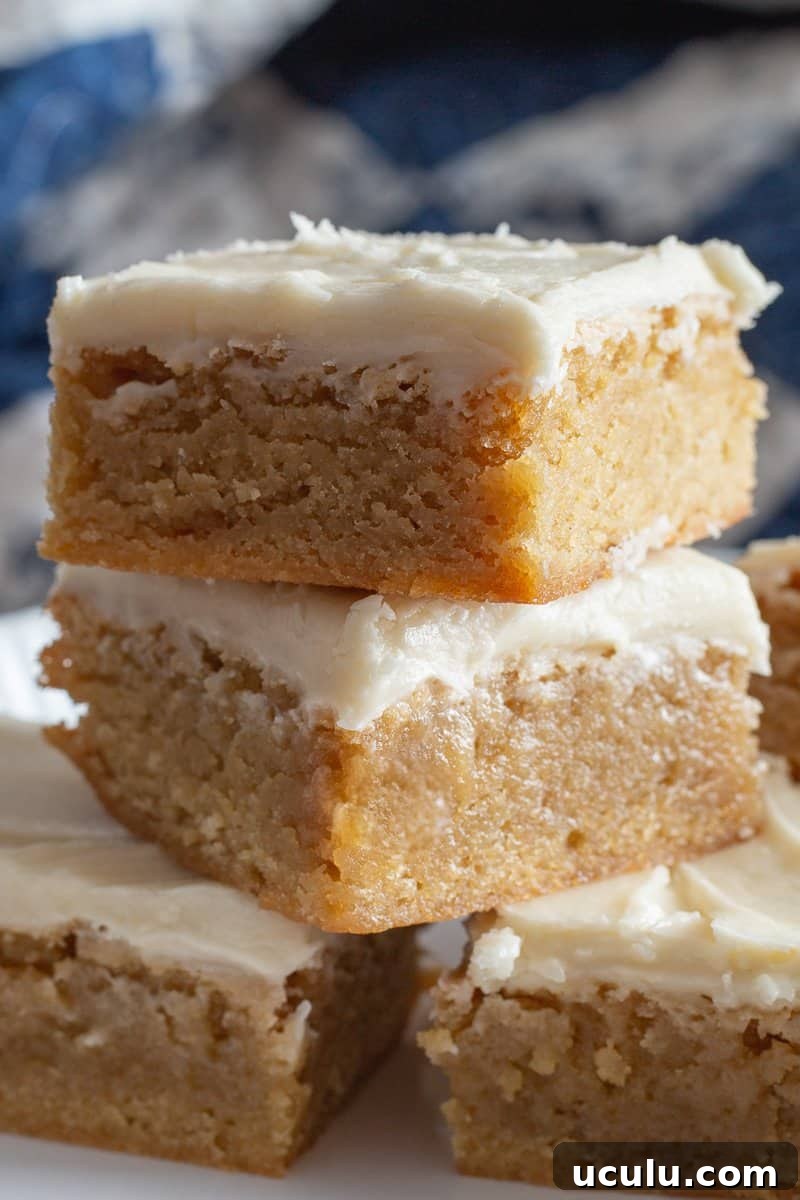 Five brownie blondies stacked on a white plate. 