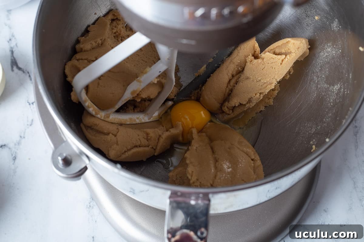 Eggs are added to butter mixture in mixing bowl.