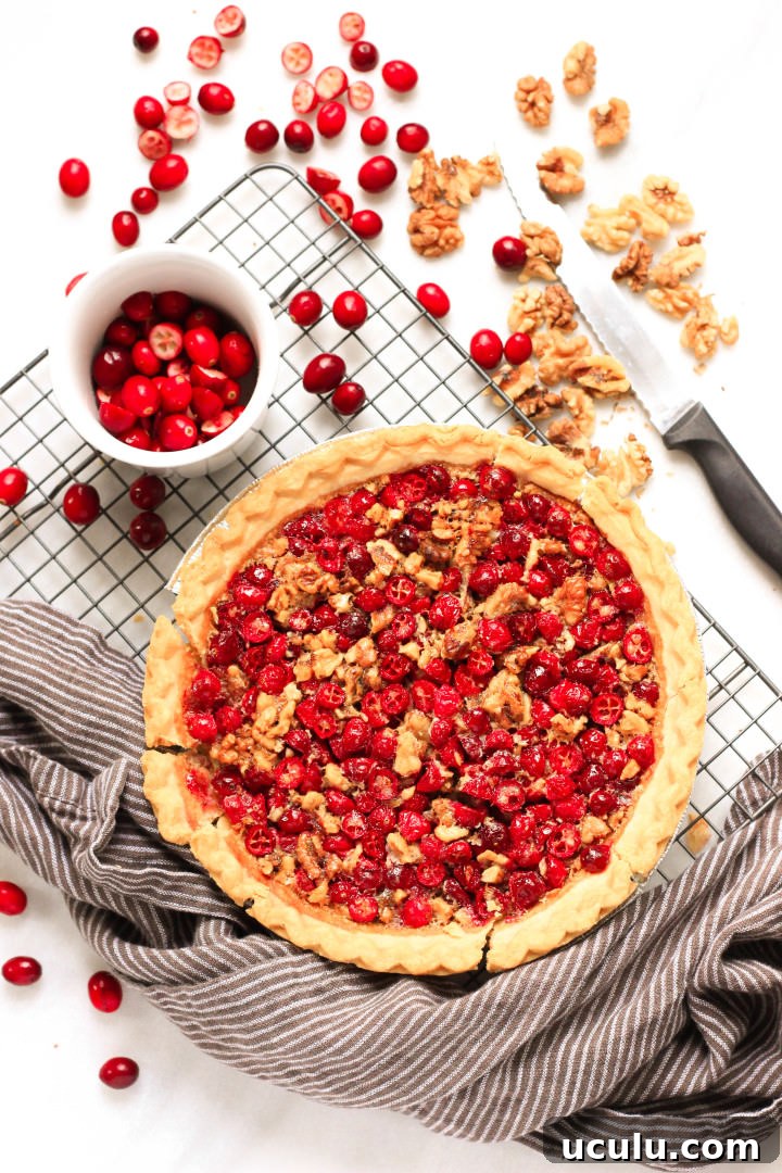 Cranberry pie and fresh cranberries on a wire rack.