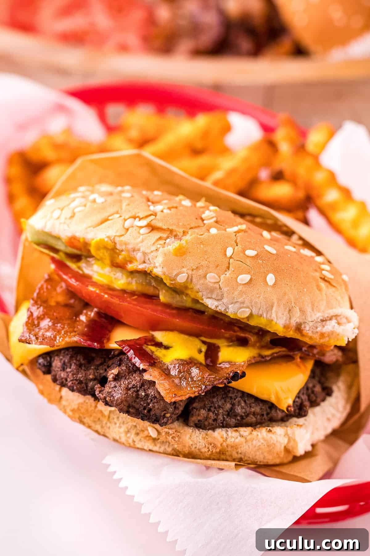 Hand holding a burger with toppings