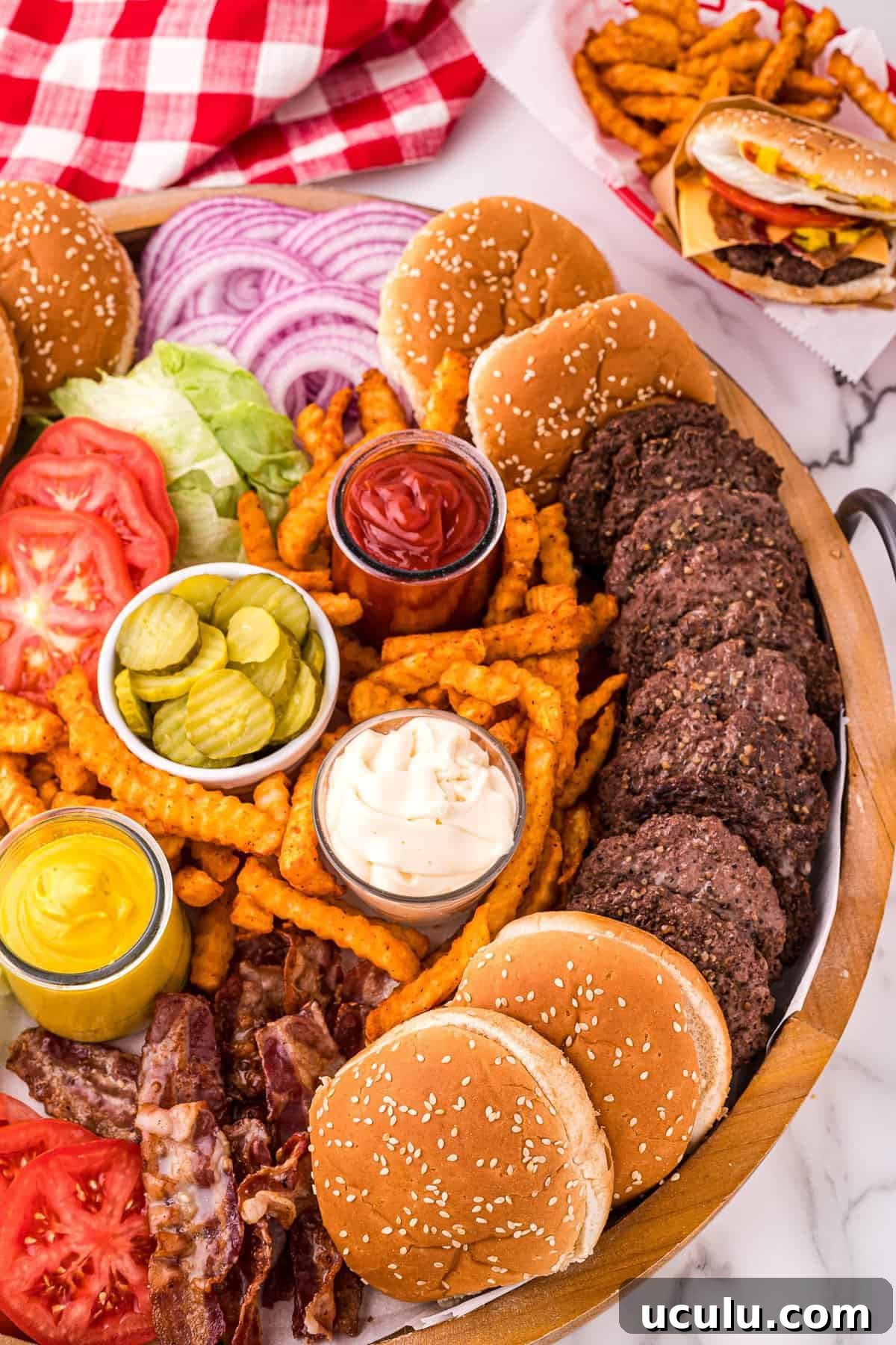 Overhead image of burger board with condiments, burgers and toppings