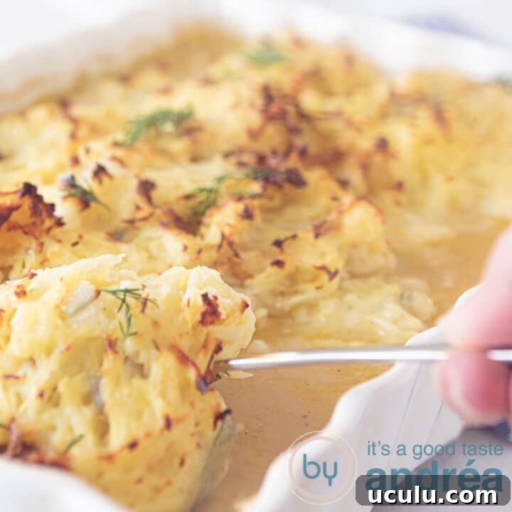 a square photo of a white casserole taking out a cod fillet with Rösti topping