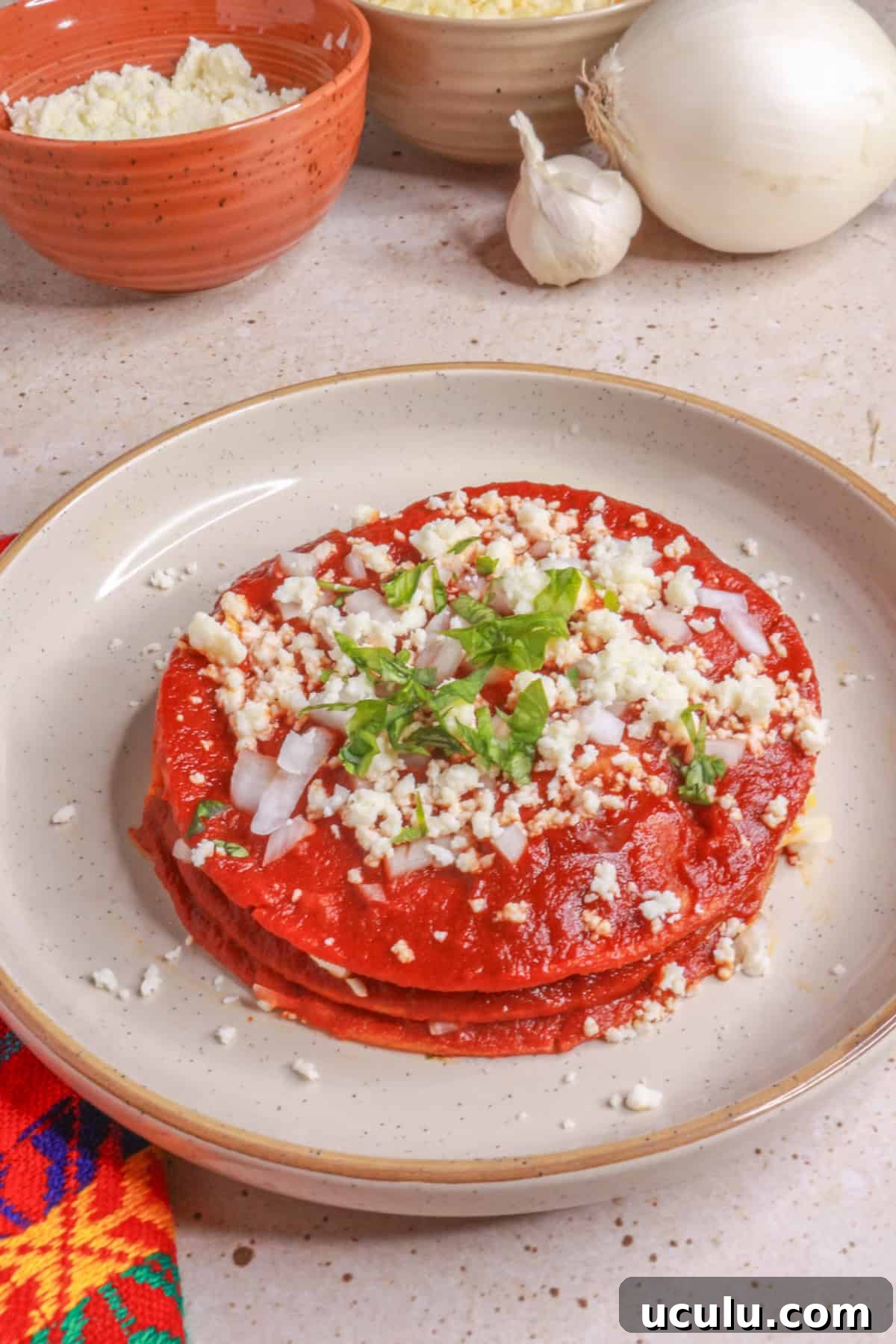 Stacked enchiladas with red sauce
