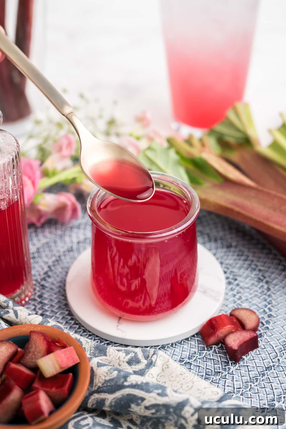 Rhubarb Simple Syrup being spooned into a jar.