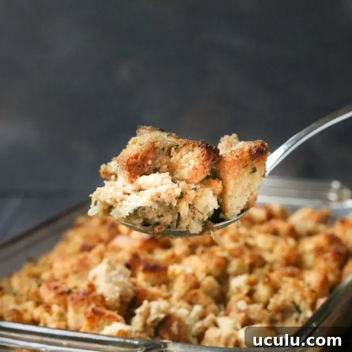 Serving spoonful of Classic Herb Stuffing held above the baking dish