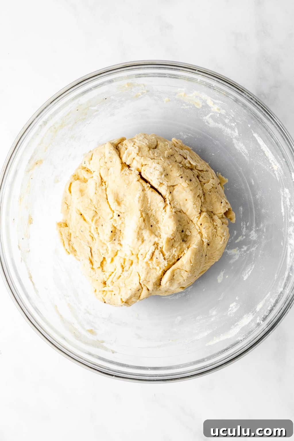 a rolled ball of dough in a glass bowl.