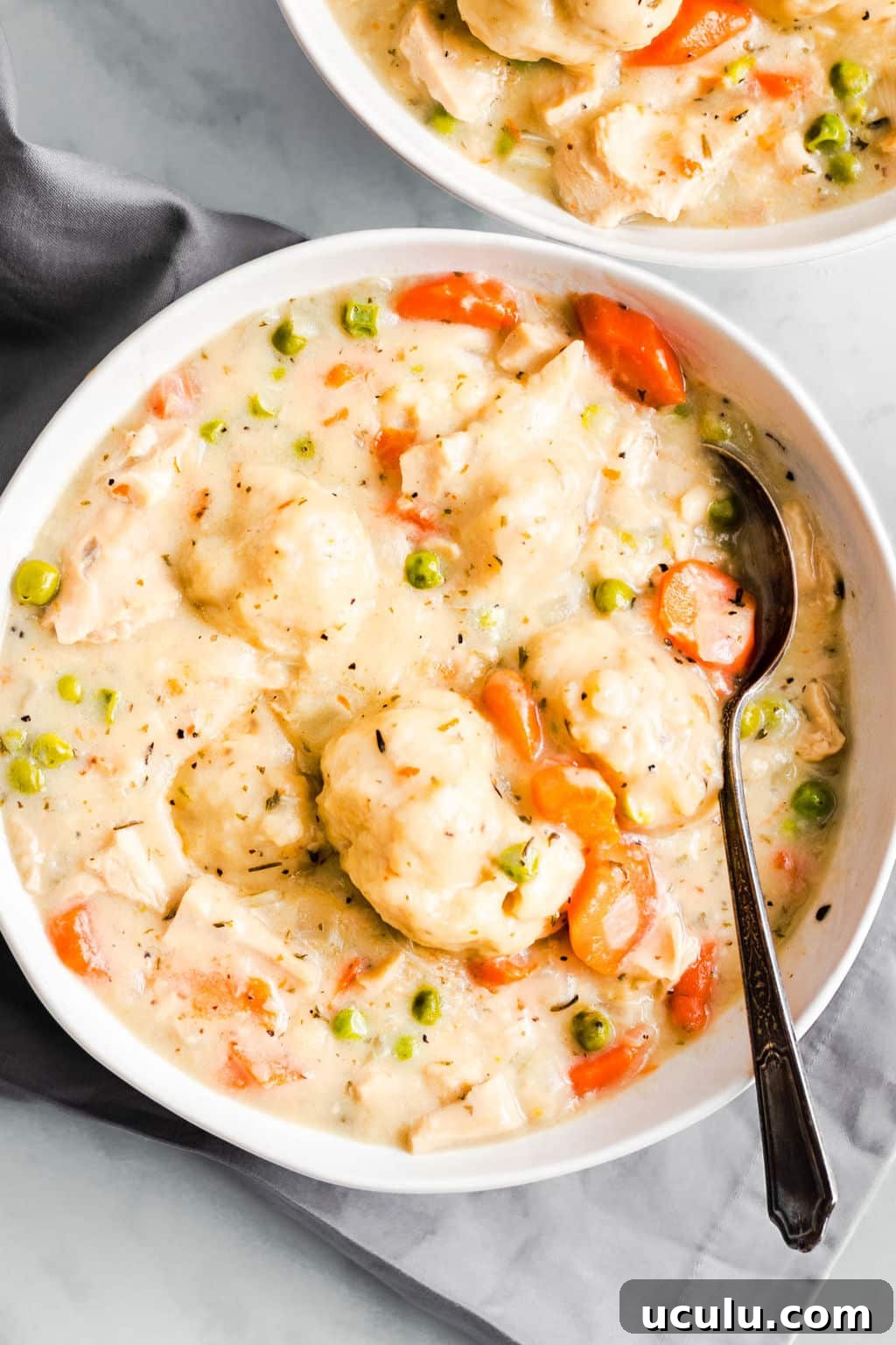 a white bowl filled with vegan chicken soup and dumplings.