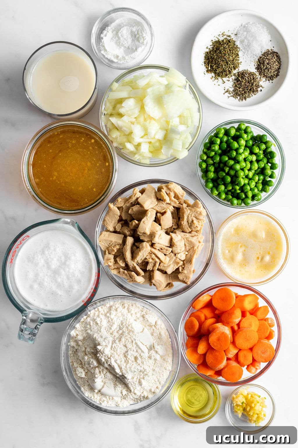 individual glass bowls filled with vegan chicken, vegetables, seasonings, flour, broth, and baking powder.