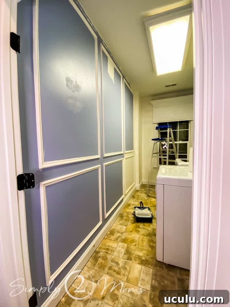 Laundry room during a makeover project with six picture moulding boxes on a wall that's being repainted