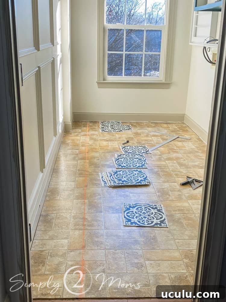 Empty laundry room with sheet linoleum flooring and materials needed to install peel and stick vinyl wallpops tiles. A chalk line has been made to line up the first row.