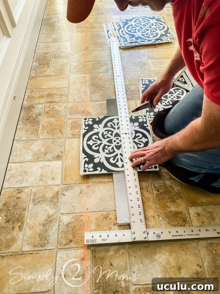 Man using a large T-square to cut a vinyl peel and stick tile