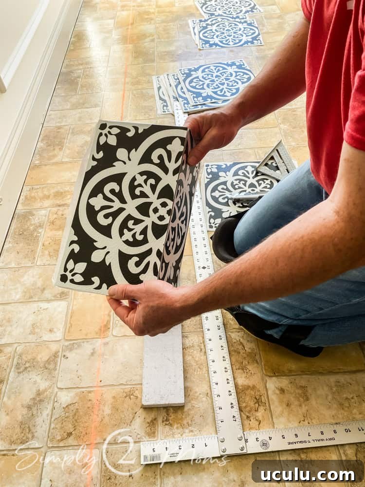 Man folding a peel and stick vinyl tile along a scored cut while installing the tiles.