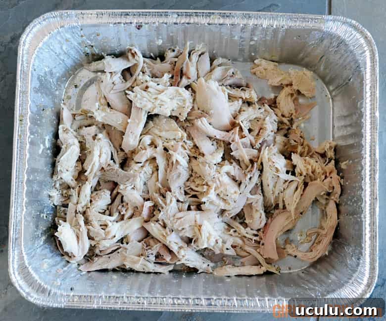 chicken pulled in an aluminum pan.