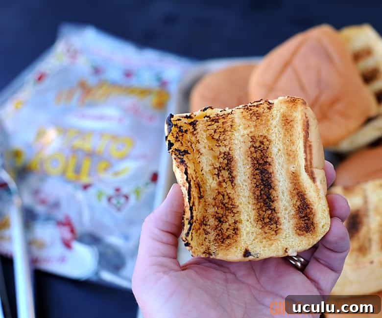 hand holding a toasted potato roll.