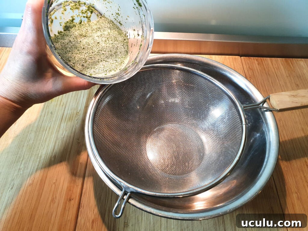 Tipping mint infused milk into strainer
