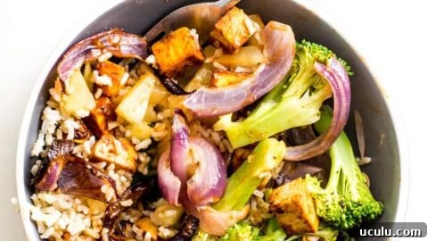 Bowl with tofu, broccoli, brown rice and roasted red onions.