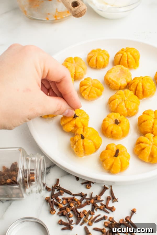Pumpkin Shaped Gnocchi cooked and getting cloves put in for the stems.