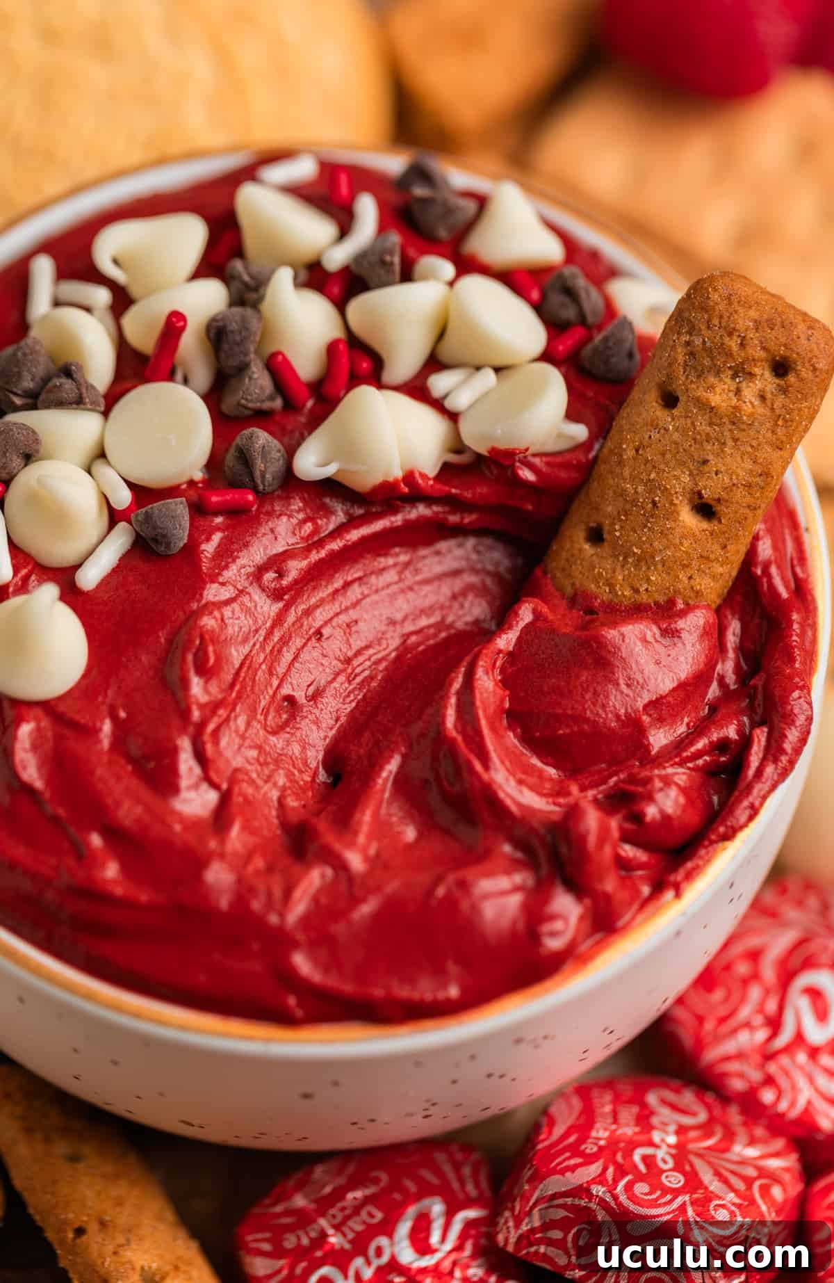 Red velvet dip with white and dark chocolate chips sprinkled on top and graham cracker dipped in.