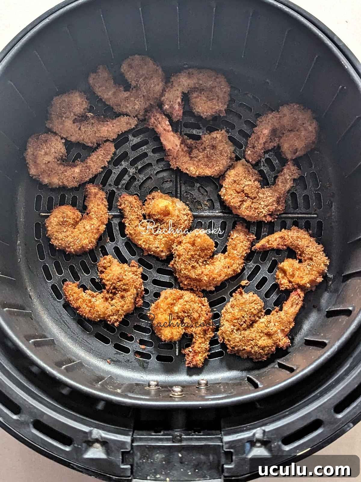 Popcorn shrimp done to perfection in air fryer basket.