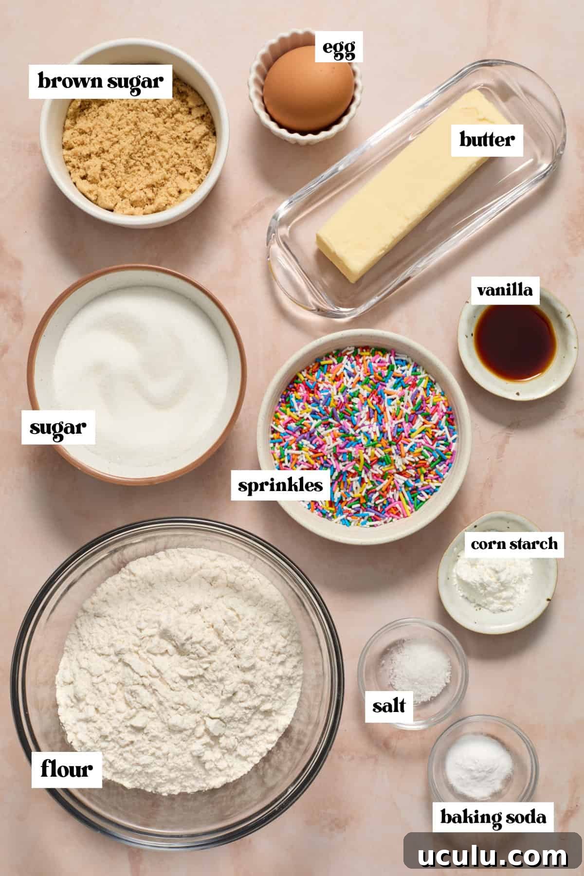 Flour, sugar, butter, and other ingredients measured and arranged on surface.