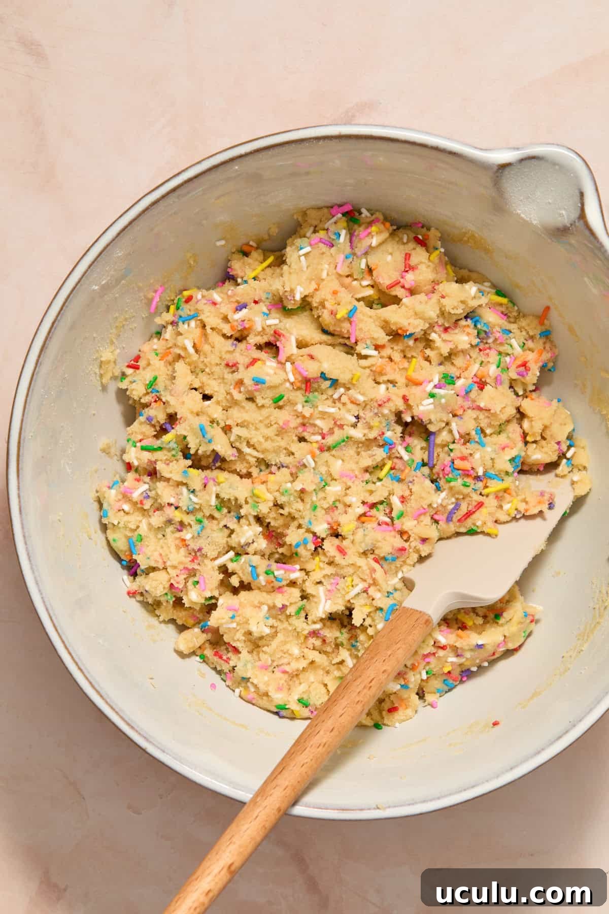Spatula in bowl with funfetti cookie dough.